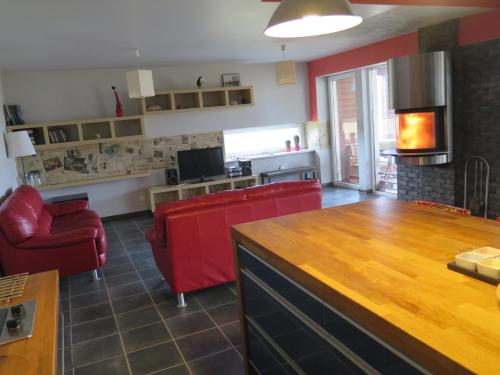 a living room with red chairs and a table at Holiday House Koceri in Ķekava