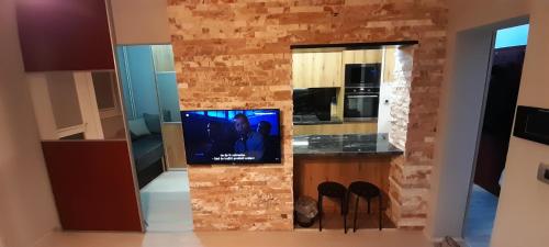 a kitchen with a tv on a brick wall at Apartment Nenov in Skopje