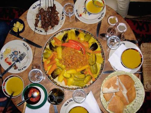 a wooden table with a plate of food on it at Auberge Ayouze in Aït Ben Haddou