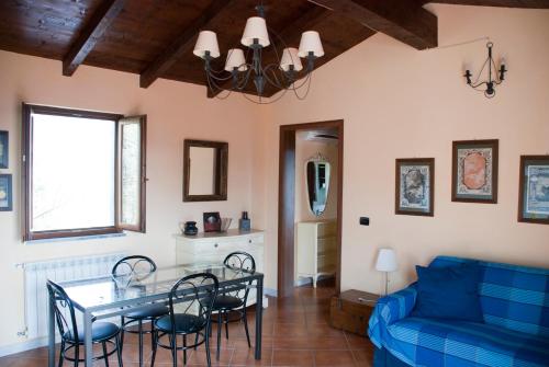 a living room with a table and a blue couch at Il Giardino delle Esperidi in Fosdinovo