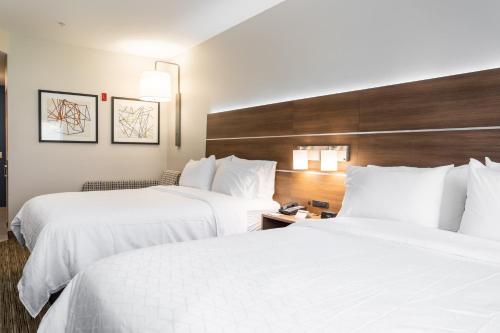 two beds in a hotel room with white sheets at Holiday Inn Express & Suites - Lake Forest by IHG in Lake Forest