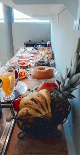 a table topped with plates of food and fruit at Pousada Coração do Parque in Penha