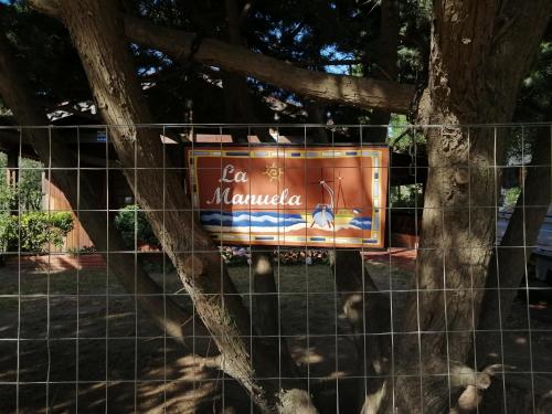 a sign on a fence next to a tree at La Manuela in Piriápolis