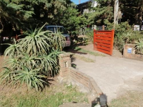 a car parked next to a driveway with a orange gate at La Manuela in Piriápolis