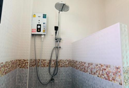 La salle de bains est pourvue d'une douche avec un pommeau de douche. dans l'établissement บ้านนอกเมืองรีสอร์ต BaanNokMueang, à Phayao