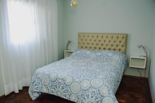 1 dormitorio con 1 cama con edredón azul y blanco en Departamento centro Cordoba capital en Córdoba