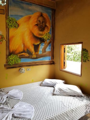 a bedroom with a painting of a monkey on the wall at A Casinha Pequenina in Monte Verde