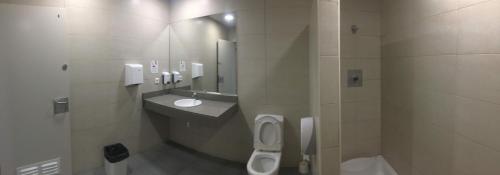 een badkamer met 2 toiletten, een wastafel en een spiegel bij Home Boat in Badalona
