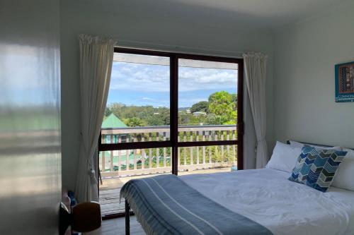 Un dormitorio con una cama y una ventana grande. en Rusty Snapper Bach - Russell, en Russell