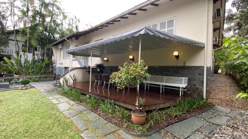 a patio with a white bench and a table at Solar 197 Pousada in Timbó