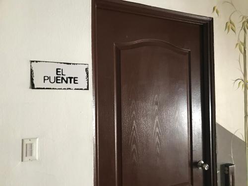a brown door with a sign that reads el plunge at CulturaHumana Guesthouse in Panama City