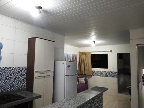 uma cozinha com um frigorífico num quarto em Quarto.sala topázio em Maceió