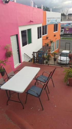 - une table blanche et 2 chaises sur la terrasse dans l'établissement Depto Las Puertas de la Ría #6, à Campeche
