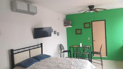 a bedroom with a bed and a green wall at Depto Las Puertas de la Ría #6 in Campeche