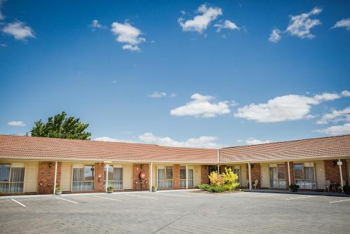 a large white building with a blue sky at Australian Settlers Motor Inn in Swan Hill