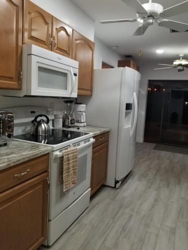 a kitchen with white appliances and wooden cabinets at Bonita Oasis in Bonita Springs