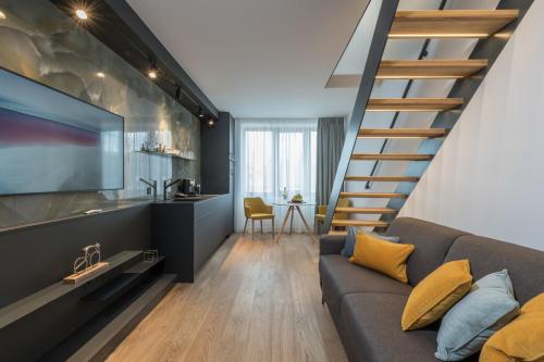プラハにあるFully renovated stylish duplex in a convenient locationのリビングルーム(階段、ソファ付)