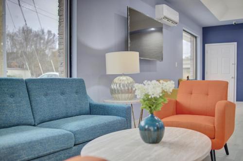 a living room with two blue couches and orange chairs at Quality Inn & Suites in Suffolk