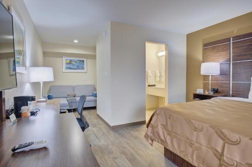 a hotel room with a bed and a couch at Quality Inn & Suites in Suffolk