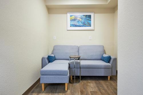 a waiting room with a blue couch and a table at Quality Inn & Suites in Suffolk
