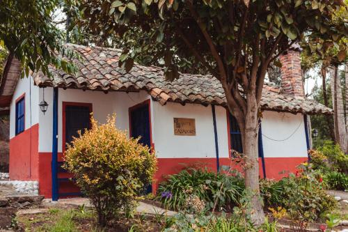a small house with a red white and blue facade at Hotel y Centro de Convenciones Pueblito de Yerbabuena Paraíso Natural in Chía