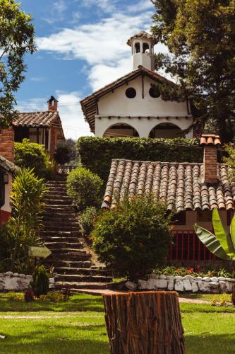a large house with stairs leading up to a building at Hotel y Centro de Convenciones Pueblito de Yerbabuena Paraíso Natural in Chía
