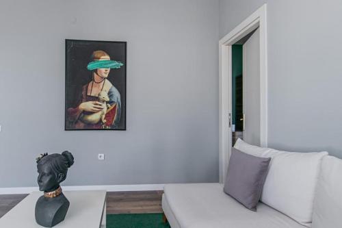 een woonkamer met een bank en een schilderij aan de muur bij Lara Suites in Antalya