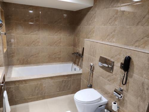 a bathroom with a toilet and a bath tub at The Raviz Calicut in Kozhikode