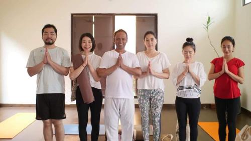 - un groupe de personnes faisant du yoga dans une chambre dans l'établissement Yogi Home Stay, à Rishikesh