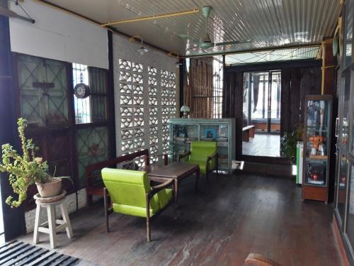 a dining room with a table and green chairs at ทุ่งยั้งเฮ้าส์ in Uttaradit