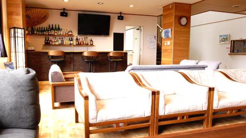 Refre Hotel في ميوكو: غرفة معيشة مع كرسيين وبار