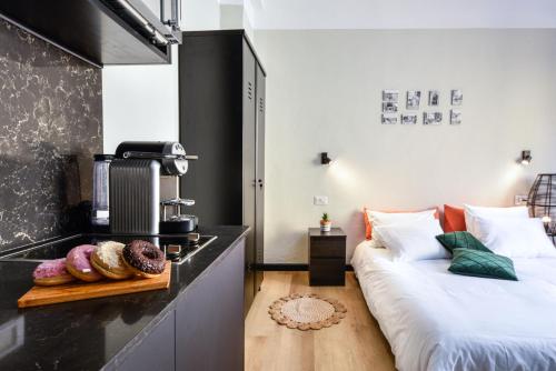 a room with two beds and a counter with donuts at Bauhaus Living with Amazing Roof Top by Sea N' Rent in Tel Aviv