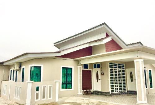 a house with a red and white at Aina Guest House in Kota Bharu