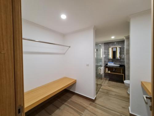 a bathroom with white walls and a toilet and a sink at Royale Suites by Arc Royal Luxury Apts in Anse Royale