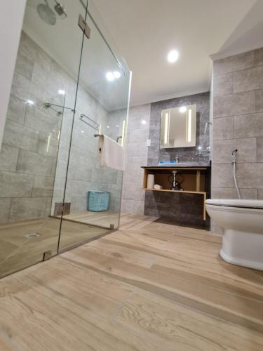 a bathroom with a shower and a toilet and a sink at Royale Suites by Arc Royal Luxury Apts in Anse Royale