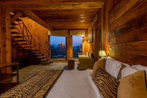 a bedroom with a bed in a room with wooden walls at The Baagh Ananta Elite Ranthambore in Sawāi Mādhopur