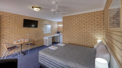 a hotel room with a bed and a tv at Gunsynd Motor Inn in Goondiwindi