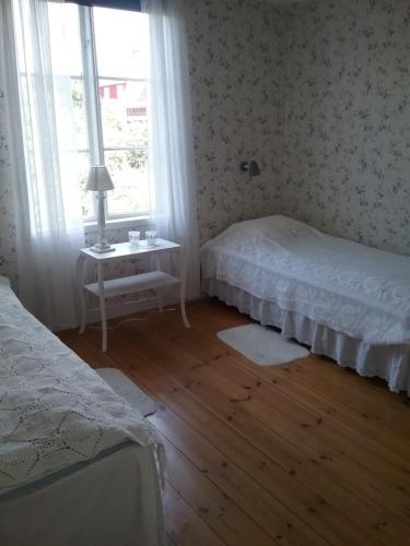 a bedroom with two beds and a window at Karlstugan Cottage in Vimmerby