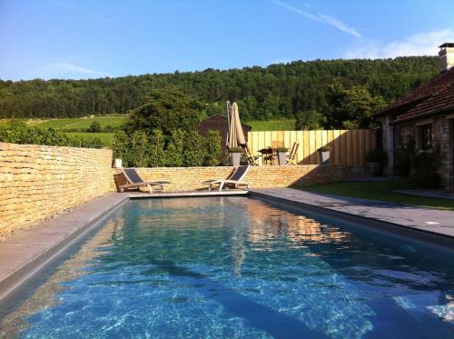 - une piscine avec deux chaises longues dans l'arrière-cour dans l'établissement Hameau de Blagny, à Puligny-Montrachet