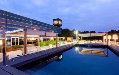 a hotel with a swimming pool in front of a building at Hotel Palau de Bellavista Girona by URH in Girona