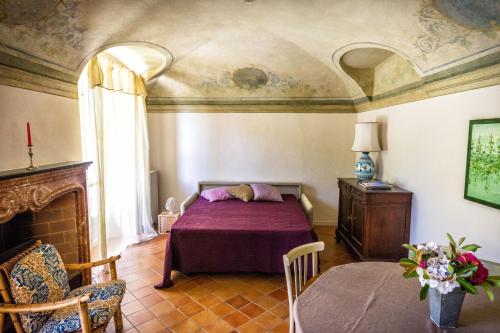 a bedroom with a bed and a fireplace and a table at Lapieve in Scalenghe