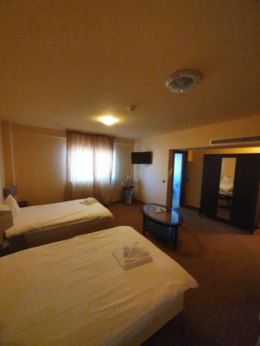 una habitación de hotel con dos camas y una mesa en Merion, en Gherla
