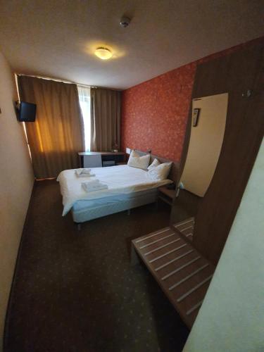 ein Hotelzimmer mit einem Bett und einer Treppe in der Unterkunft Merion in Gherla