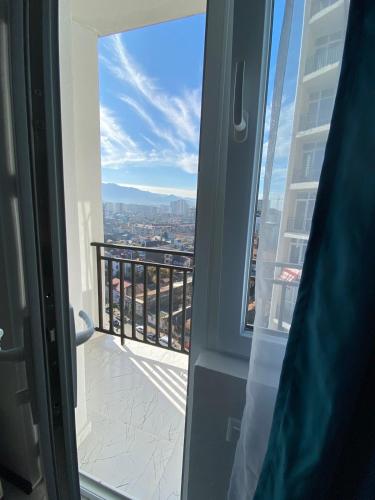 an open door to a balcony with a view of a city at Lovely Apartment in City Center in Batumi