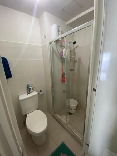 a small bathroom with a toilet and a shower at Elize Wind Residences in Tagaytay