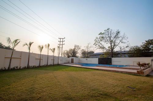 a white fence with palm trees in front of a building at VIVANA in Dhanbād
