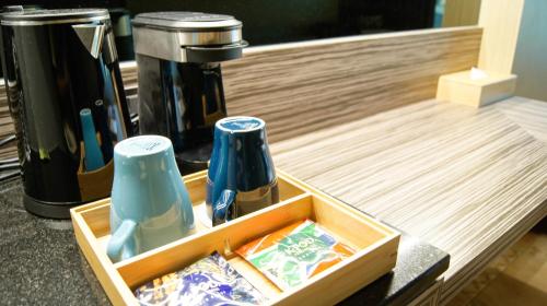 a wooden tray with two bottles and a coffee maker at Kuei Ti Wan Hotel in Checheng