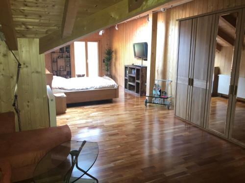 sala de estar con cama y suelo de madera en Monikas Ferienwohnung, en Stiefenhofen