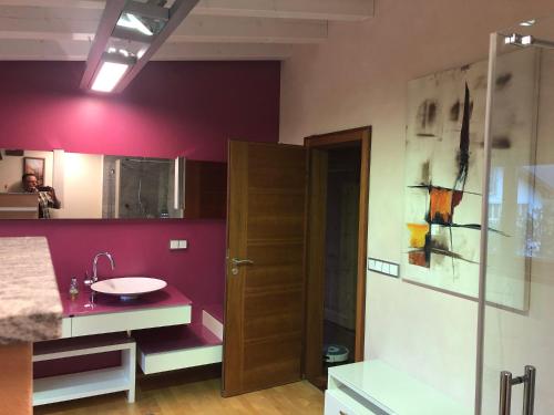 baño con lavabo y pared roja en Monikas Ferienwohnung, en Stiefenhofen