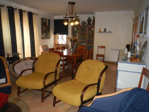 a living room with a dining room table and chairs at Casa da Barra in Praia da Barra